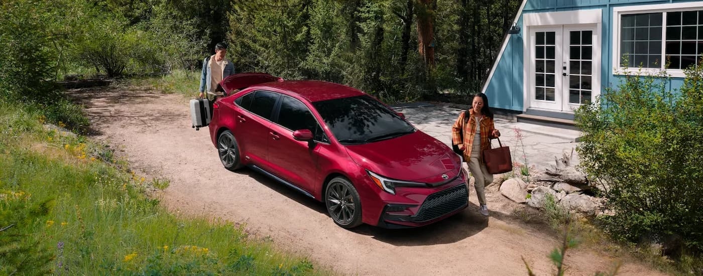 Red 2026 Toyota Corolla parked on a dirt driveway.