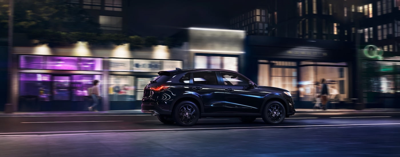 Black 2026 Honda HR-V driving down a road.