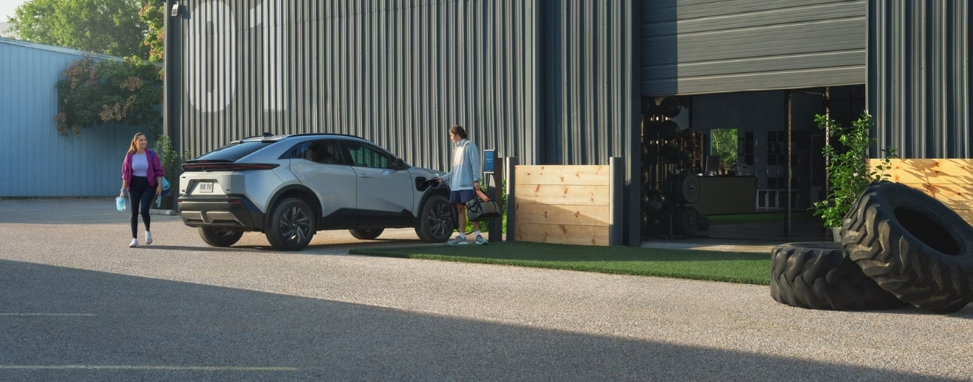 Silver 2026 Toyota C-HR SE parked in front of a metal building