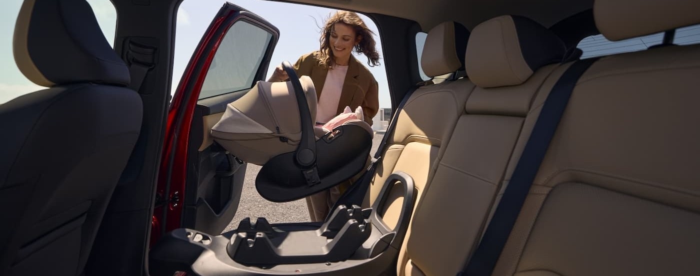 A parent putting a car seat into a 2025 Mazda CX-5.