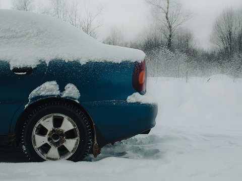 blue snow covered car with winter tires