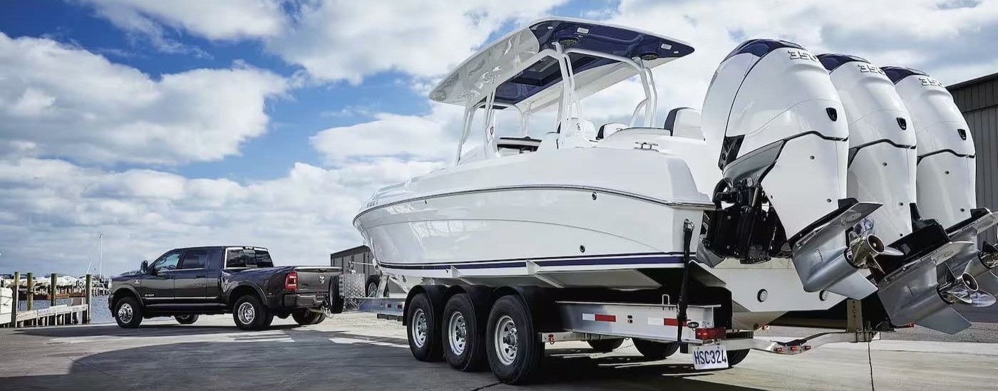 Rear of a black 2024 Ram 3500 towing boats.