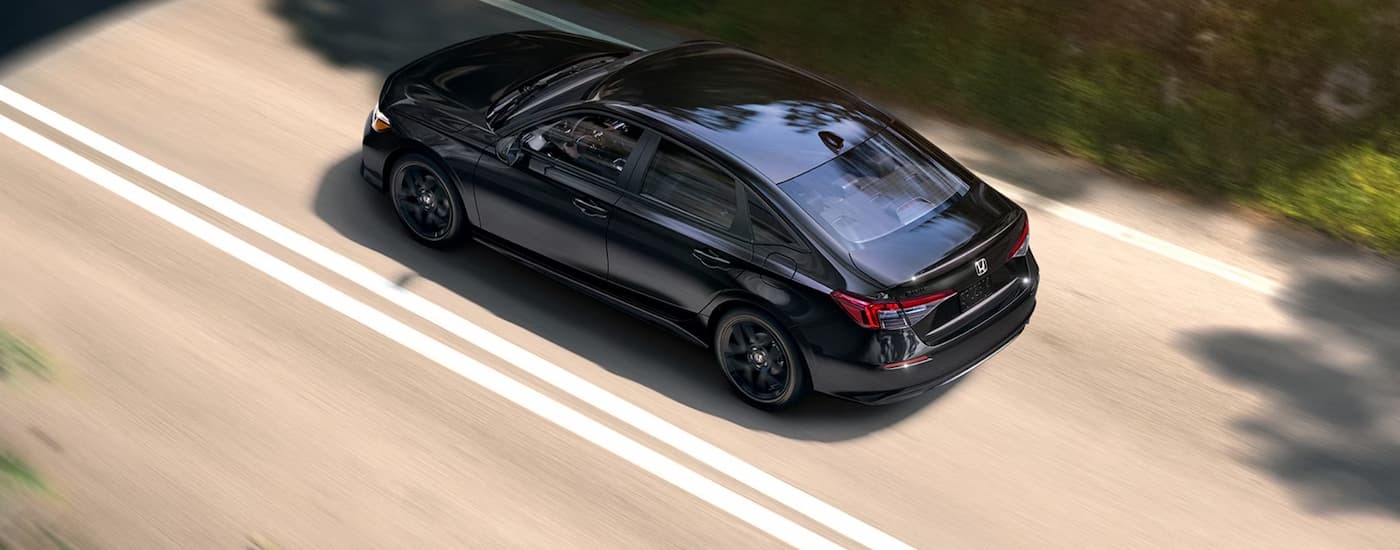 High view of a black 2026 Honda Civic driving down a road.