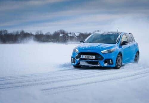 Blue Ford Focus driving on Snow