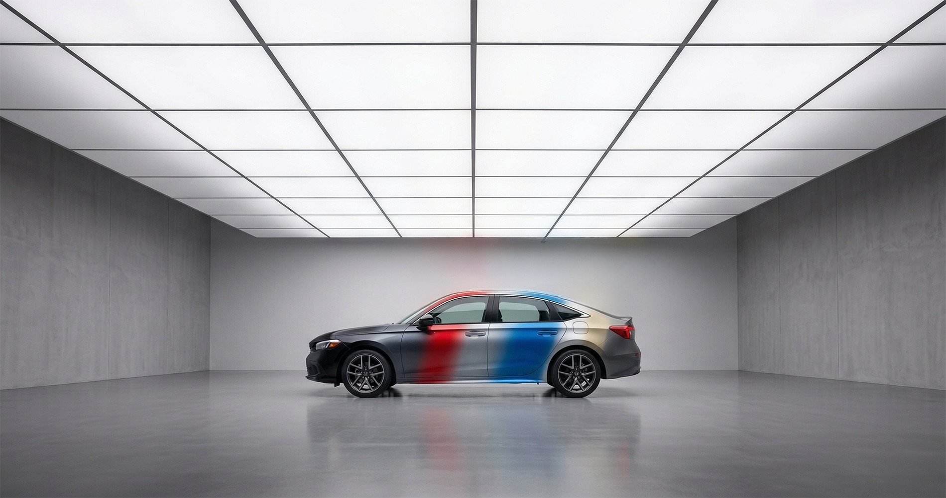 026 Honda Civic sedan in a clean studio environment showing a smooth multi-color paint transition across the body, highlighting available exterior color options with soft lighting and reflective floor