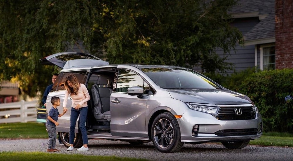 People getting out of a parked silver 2023 Honda Odyssey.