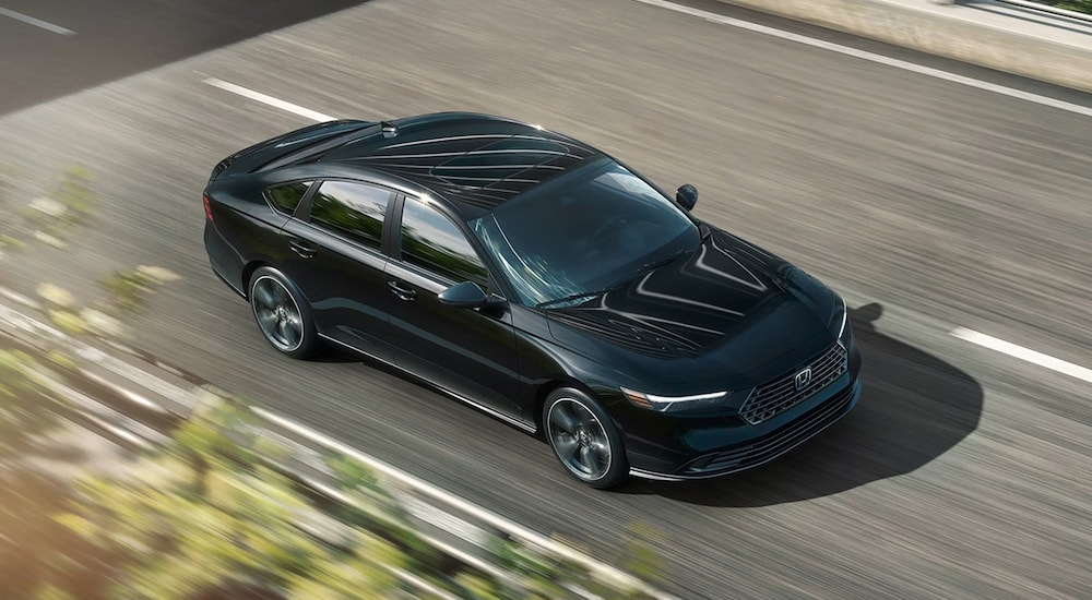 High view of a black 2026 Honda Accord driving down a road.