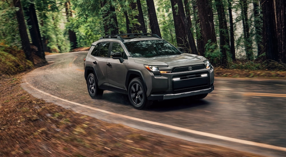 Grey 2026 Toyota RAV4 driving through a forest.