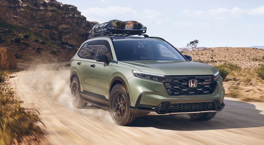 A green2026 Honda CR-V TrailSport off-roading on a trail