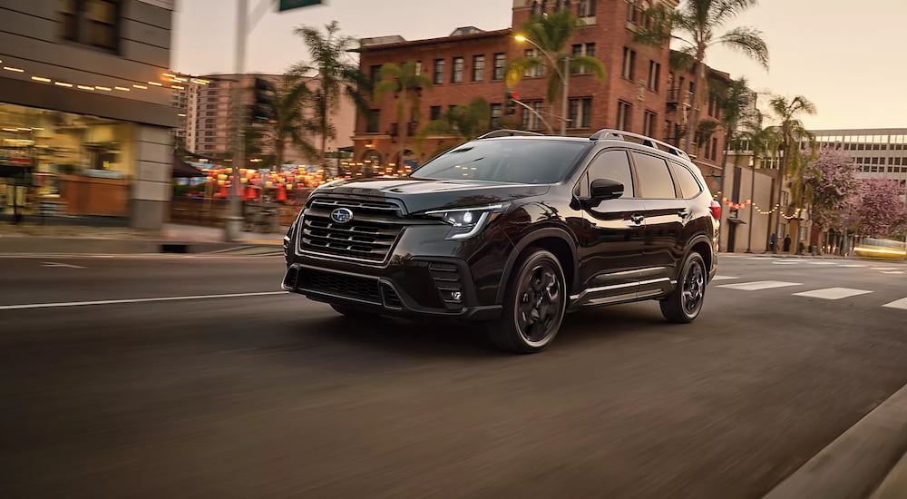 Black 2026 Subaru Ascent driving down a city street.