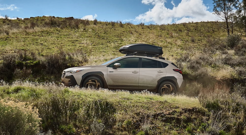Side of a white 2026 Subaru Crosstrek driving off-road.