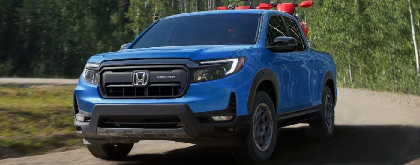 Blue 2026 Honda Ridgeline driving on a dirt road