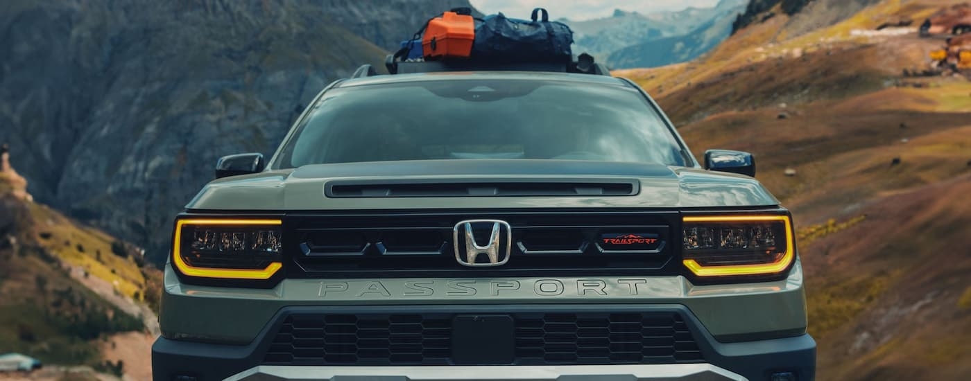 Front of a green 2026 Honda Passport on a mountain trail