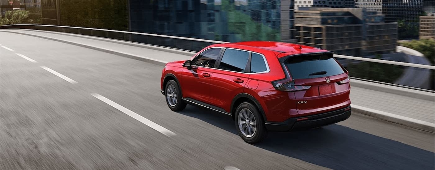 Red 2026 Honda CR-V driving on a highway bridge