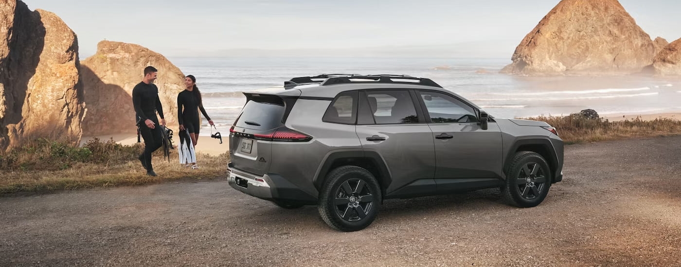 Rear of a grey 2026 Toyota RAV4 parked near a lake.