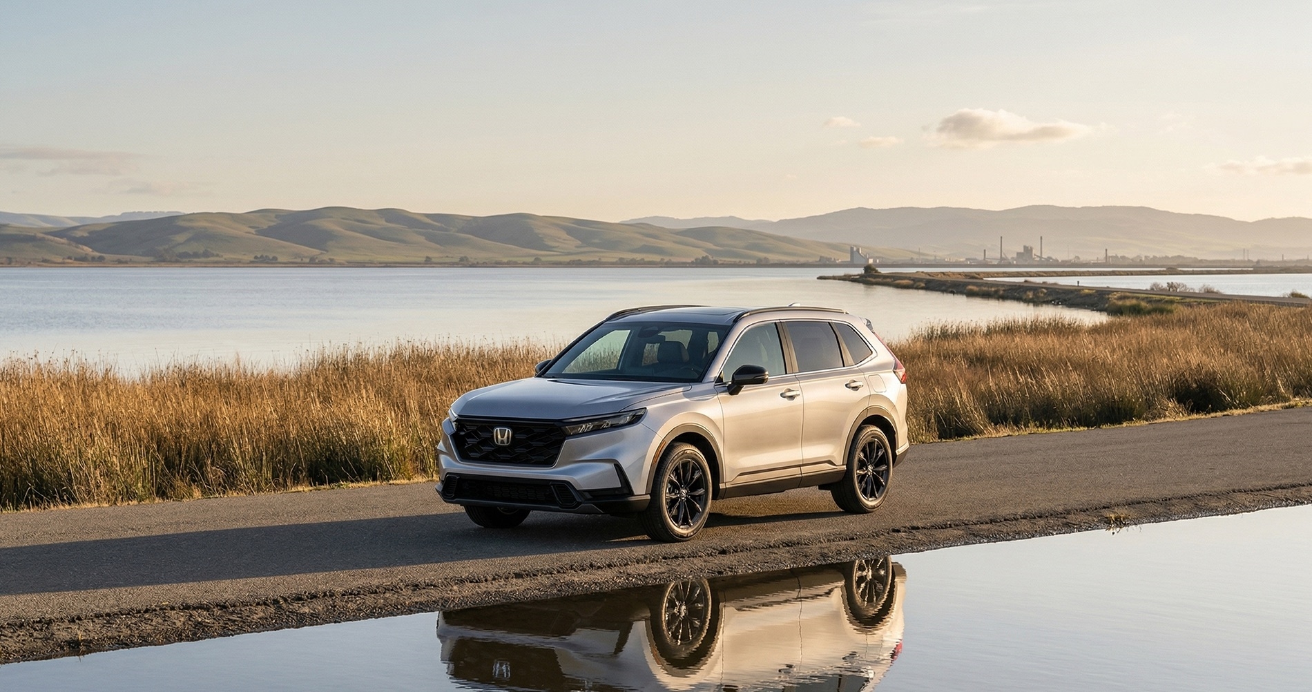 2026 Honda CR-V driving along a levee road in the Sacramento–San Joaquin River Delta near Pittsburg, CA at golden hour