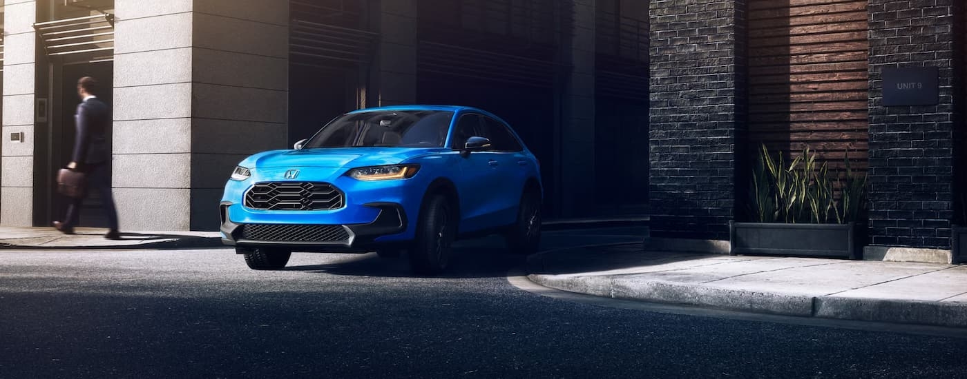 Blue 2026 Honda HR-V driving through a city alley