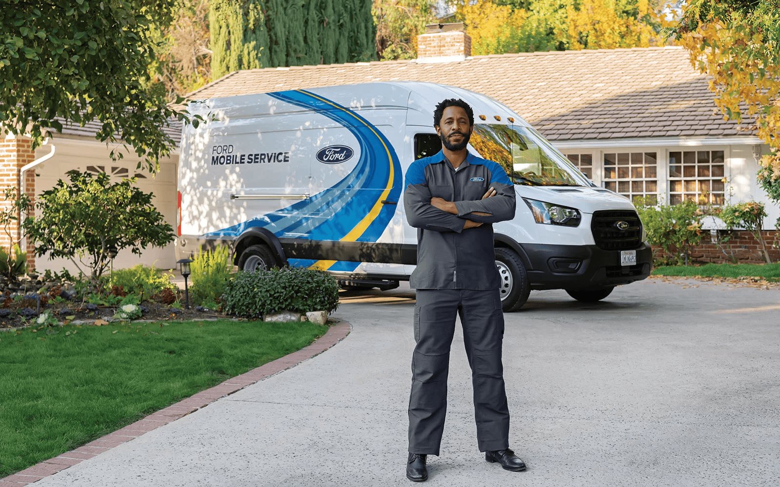 Ford Mobile Service technician standing in front of service van at residential home
