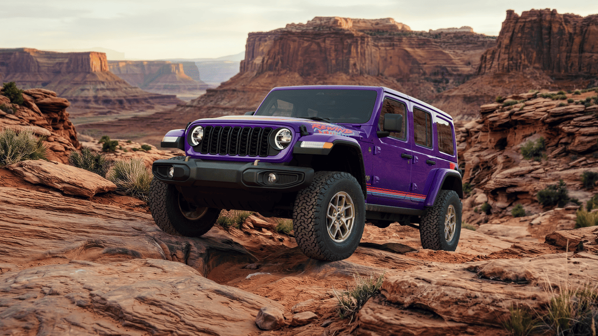 2026 Jeep Wrangler in Margate FL in purple with Rewild graphics package, large off-road tires, and round LED headlights on rocky red rock canyon terrain