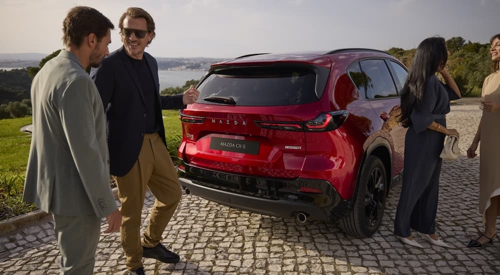 Rear of a red 2026 Mazda CX-5 parked outside a building.