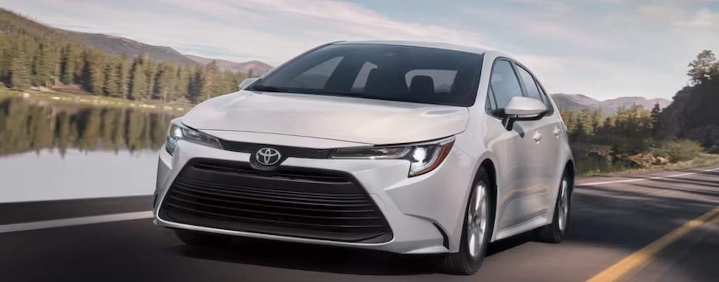 A white 2026 Toyota Corolla driving down a road