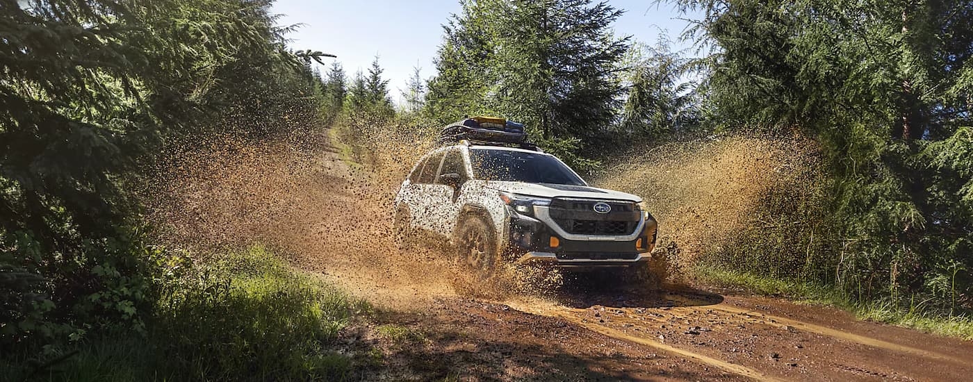 A white 2026 Subaru Outback off-roading in mud