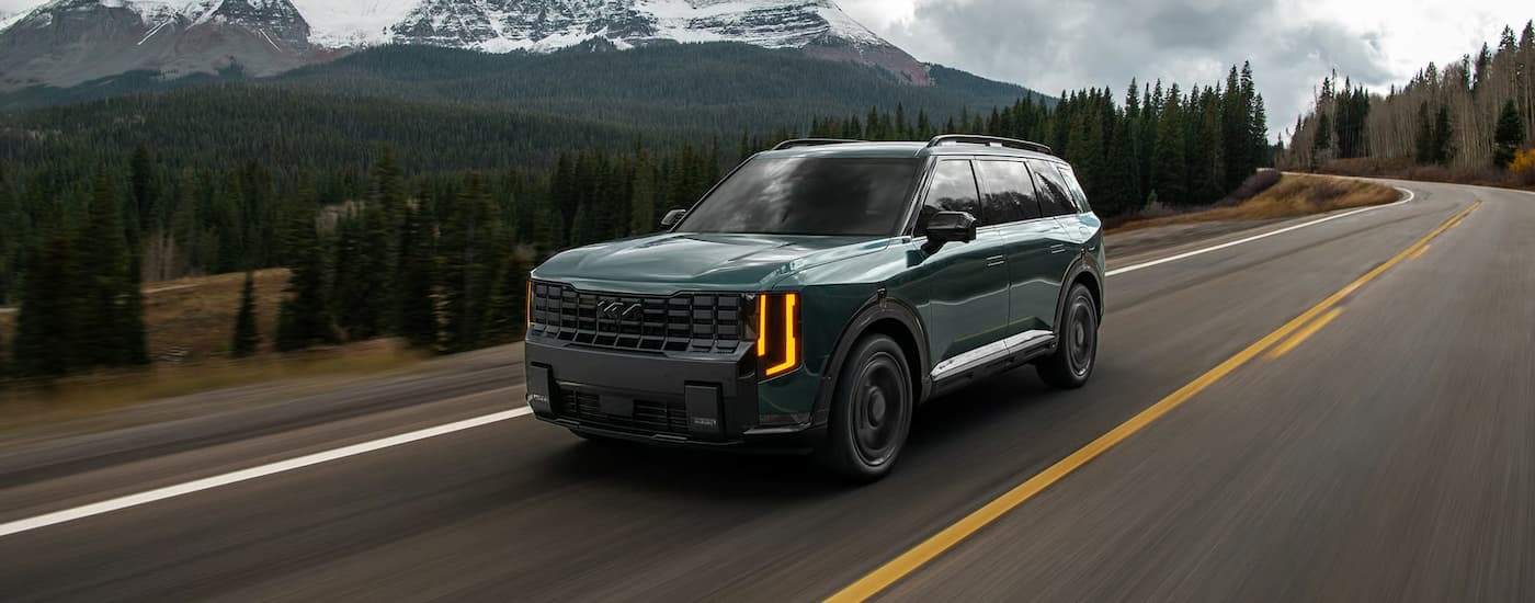 Green 2026 Kia Telluride driving down an open road.