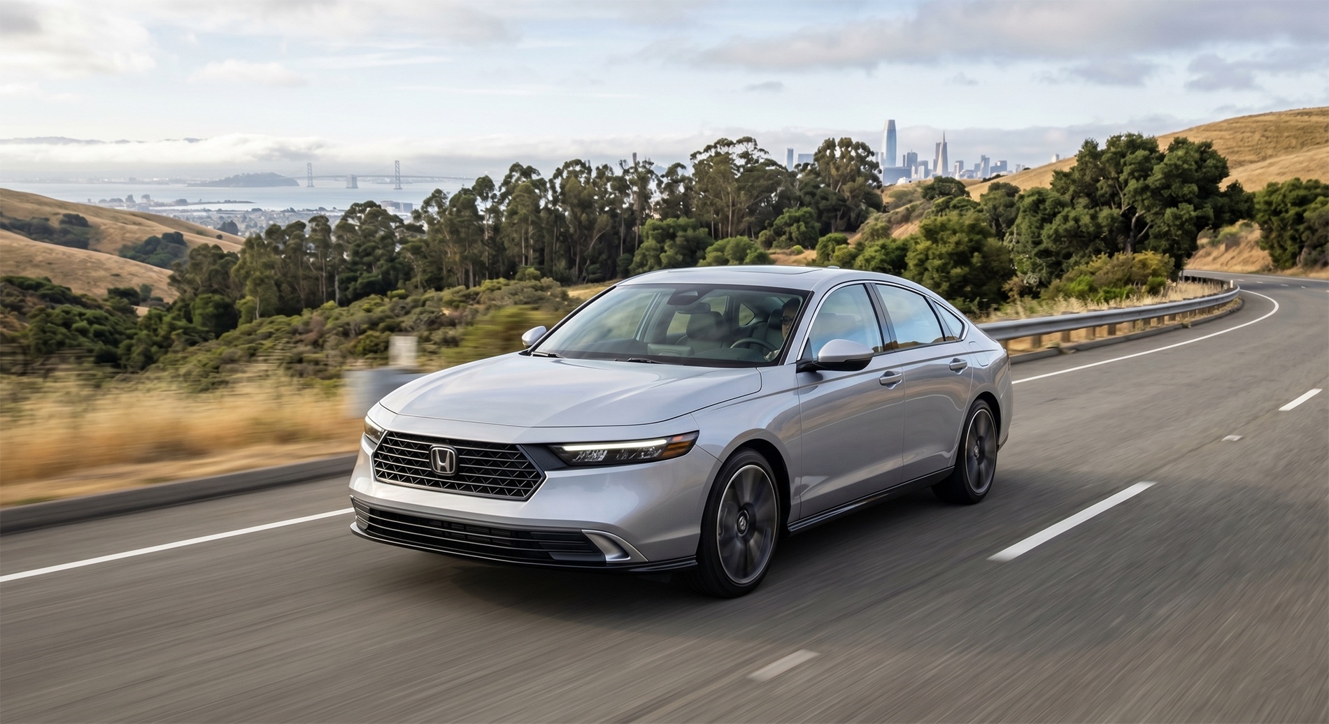 2026 Honda Accord driving on a smooth East Bay road with rolling hills and light bay views, showing real-world commuting and fuel-efficient performance