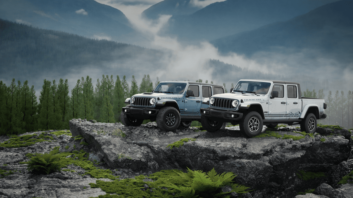 2026 Jeep Grand Cherokee in deep red parked on a gravel overlook with green mountain backdrop, showcasing seven-slot grille and premium alloy wheels for drivers in Margate FL