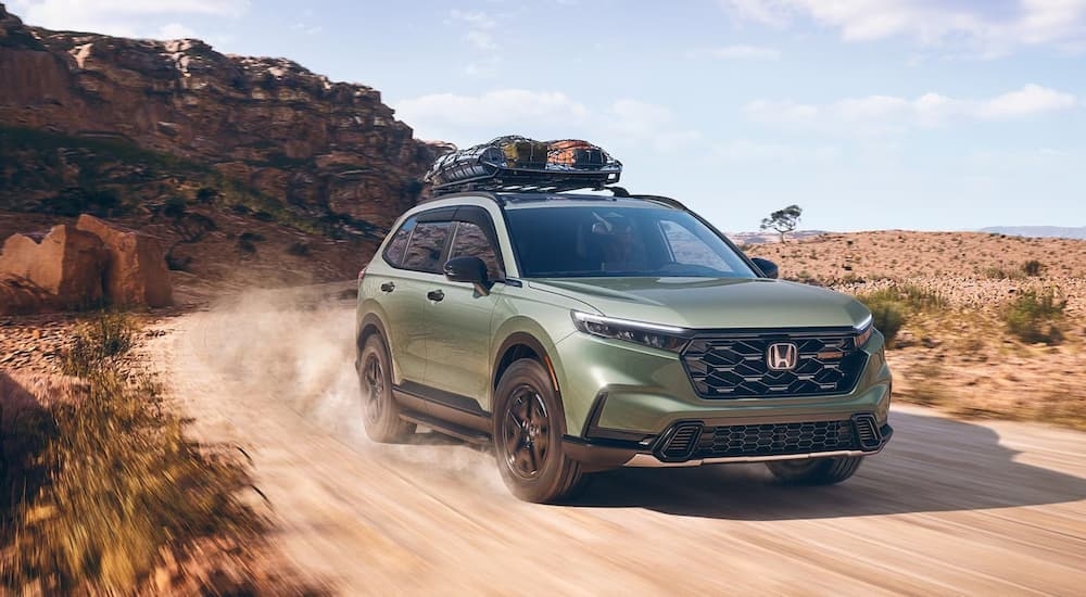 Green 2026 Honda CR-V off-roading on a dusty road