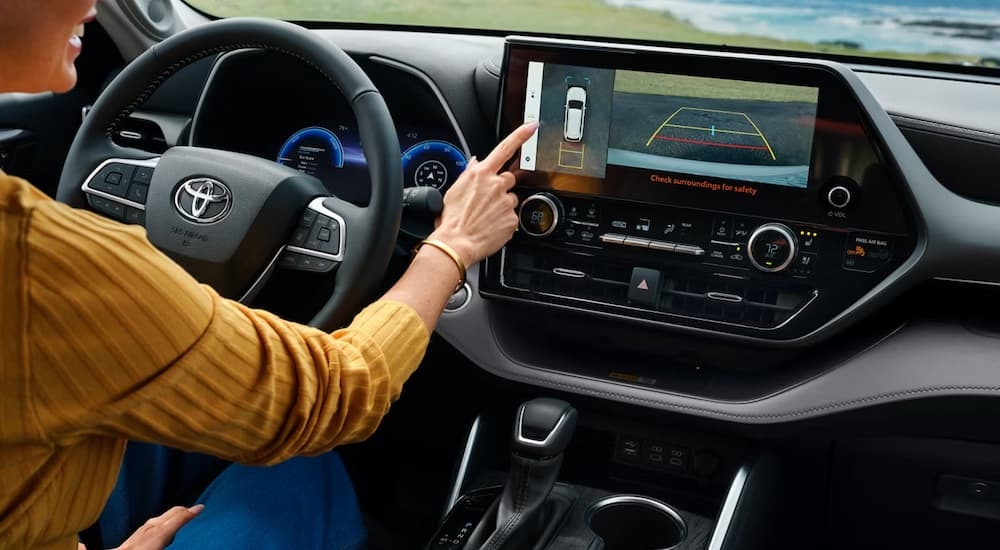 Woman using infotainment screen in a 2026 Toyota Highlander