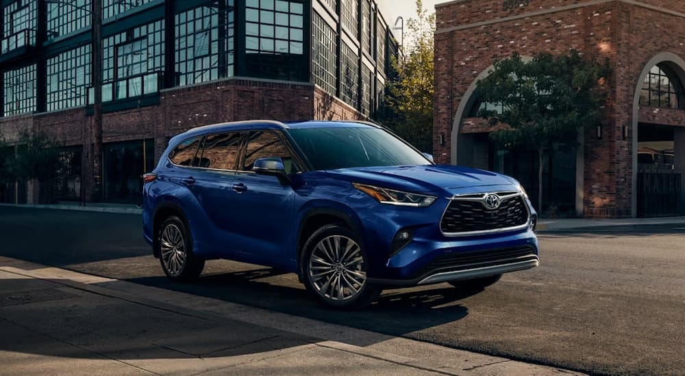 Blue 2026 Toyota Highlander parked on the side of a city street