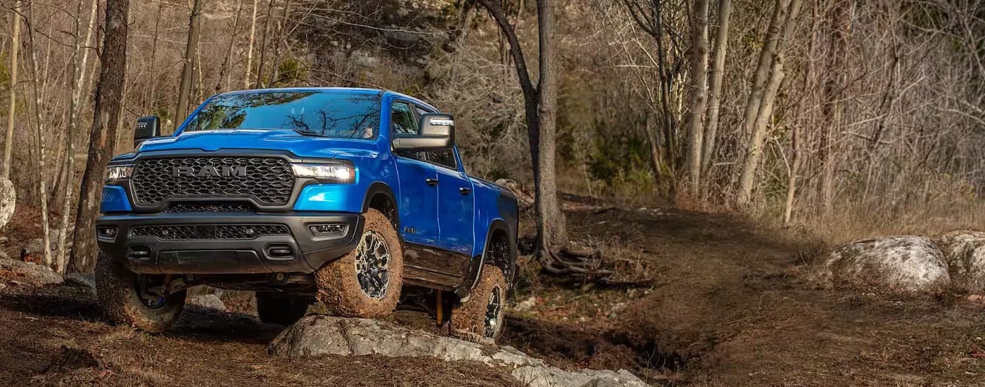 Blue 2025 RAM 1500 parked off-road on a hill.