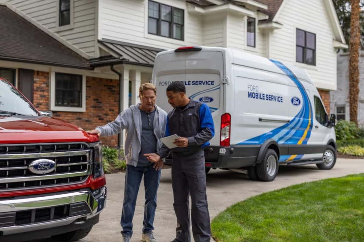 Ford mobile service technician working on vehicle at customer home driveway