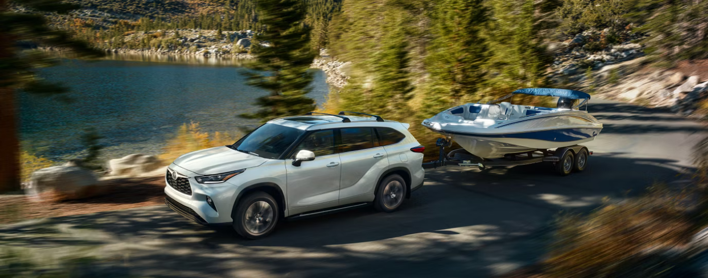 White 2026 Toyota Highlander towing a boat