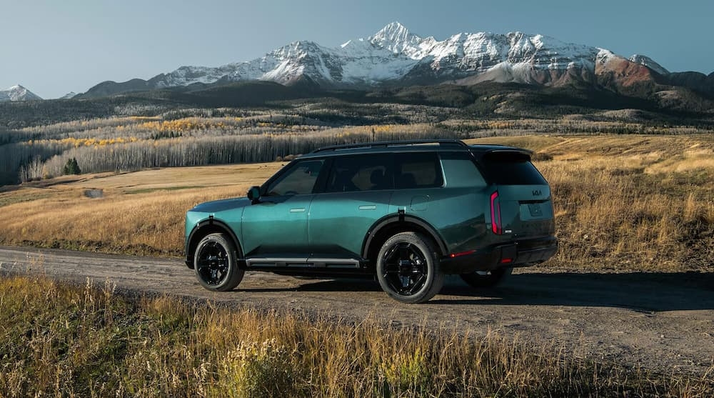 A green 2027 Kia Telluride X-Line SX Prestige parked near a mountain.