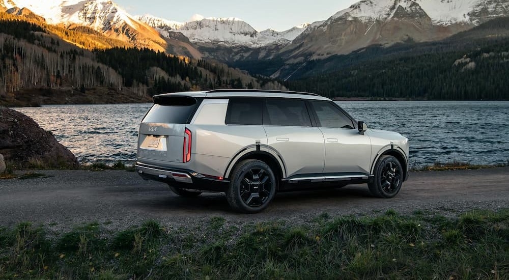 A silver 2027 Kia Telluride parked near a lake.