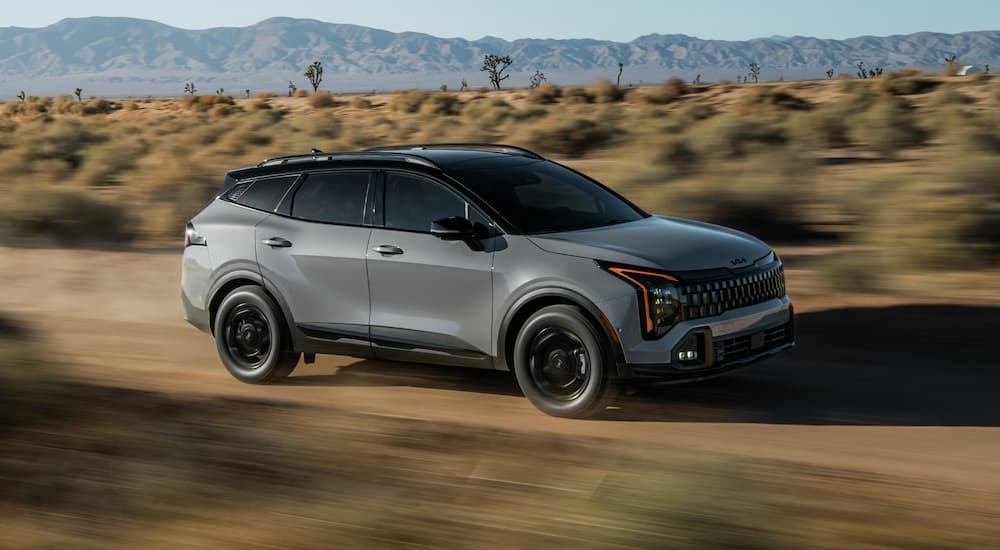 Grey 2026 Kia Sportage driving off-road.