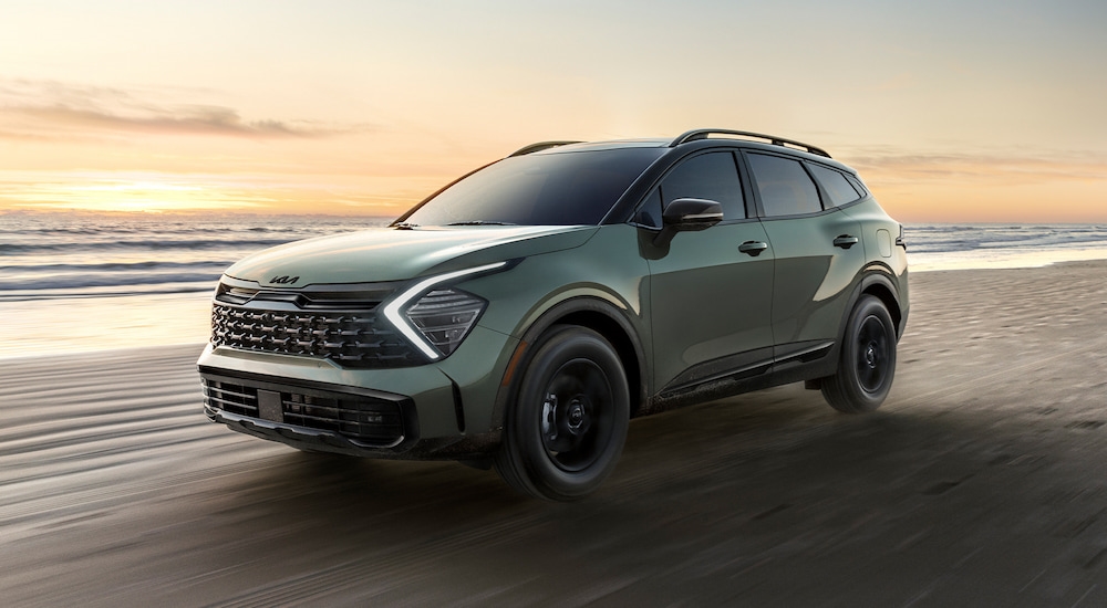 Green 2026 Kia Sportage driving off-road.