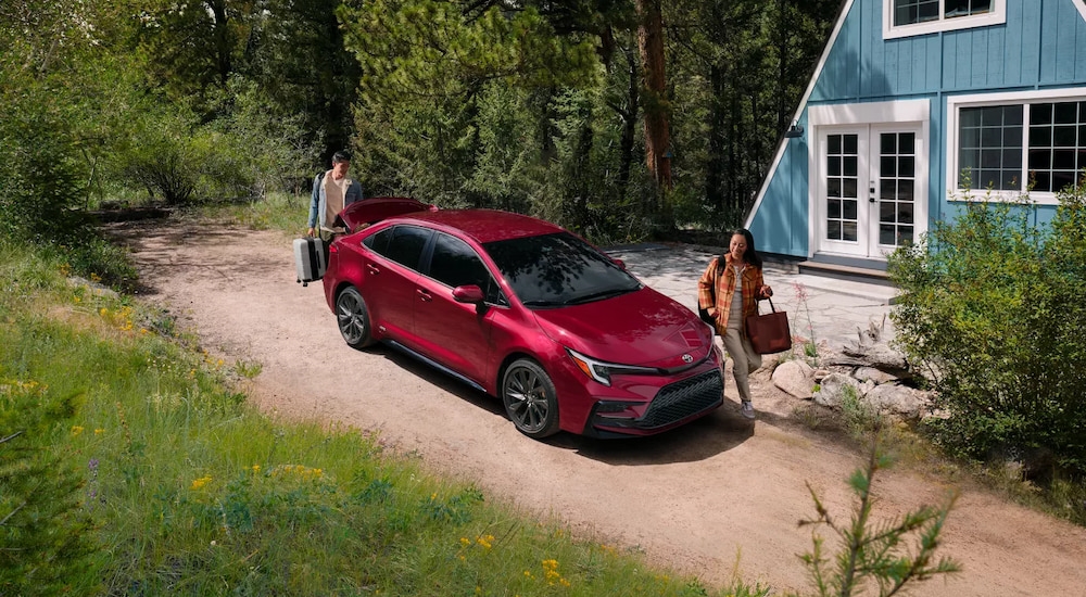 Red 2026 Toyota Corolla parked outside of a house.