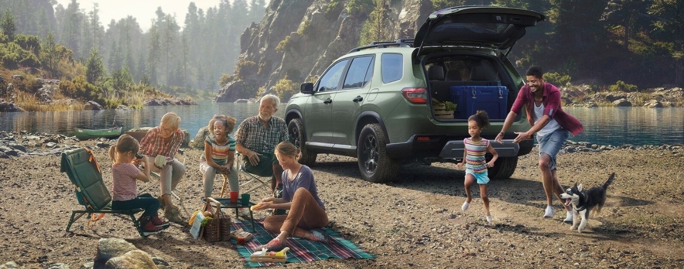 People having a picnic near a green 2026 Honda Pilot TrailSport 