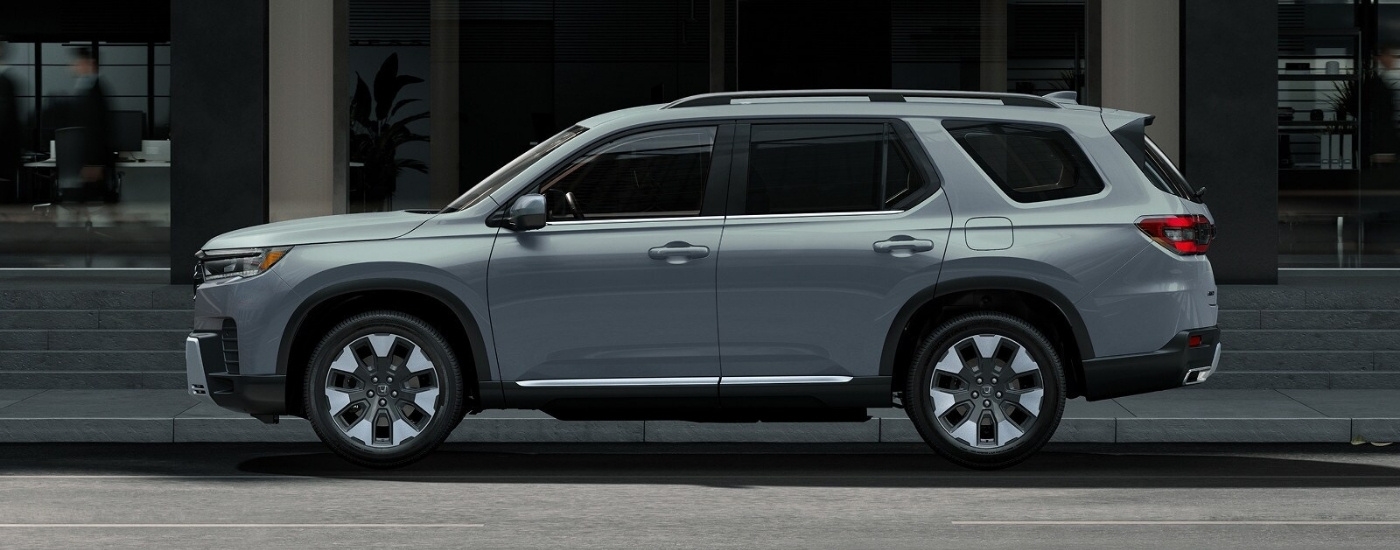 Grey 2026 Honda Pilot Elite parked in front of a building