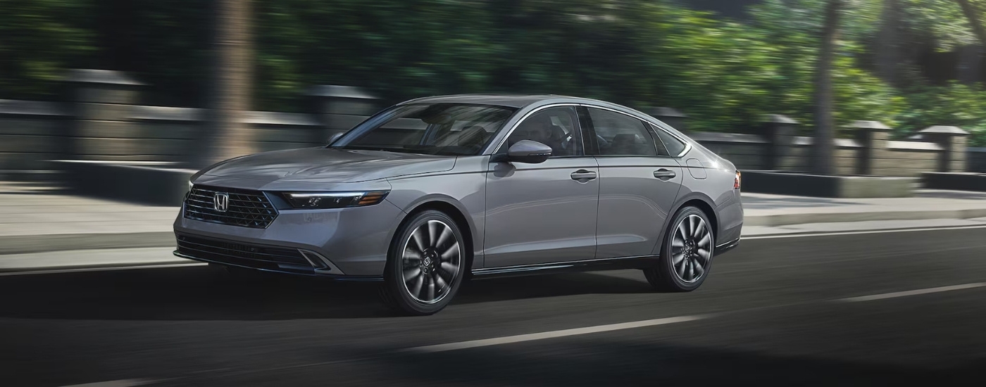 Grey 2026 Honda Accord Hybrid driving on a city street