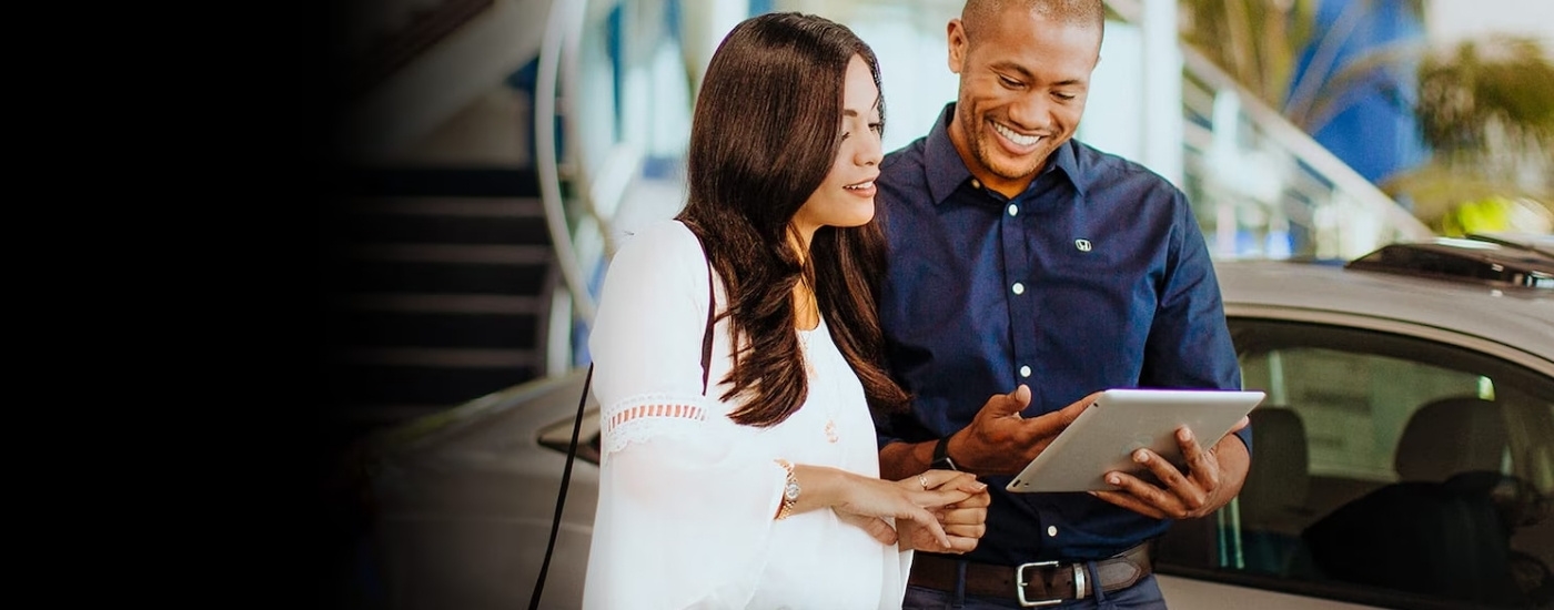 Smiling salesperson and cutomer looking at a tablet