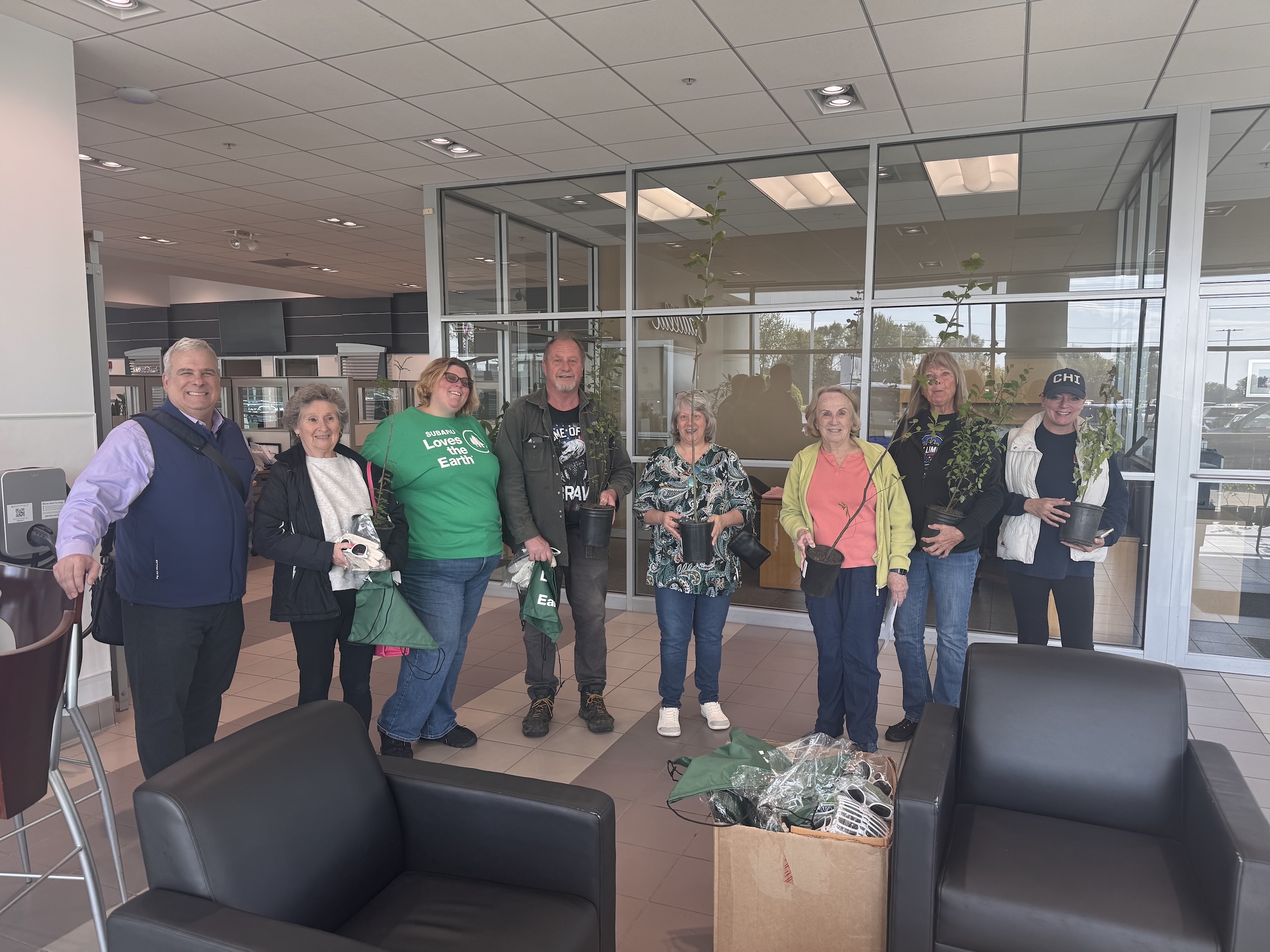 Community members at Subaru McHenry holding free trees during Subaru Loves the Earth