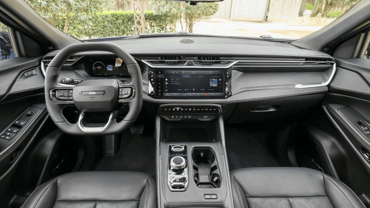 2026 Jeep Cherokee interior in Margate FL with Jeep-branded flat-bottom steering wheel, wide touchscreen infotainment, rotary gear selector, and all-black dashboard trim