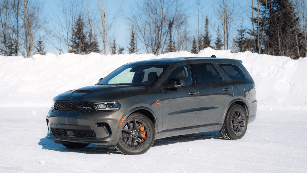 2026 Dodge Durango SRT in Margate FL in dark gray with SRT hood scoop, black alloy wheels, orange brake calipers, and aggressive front fascia parked on snow