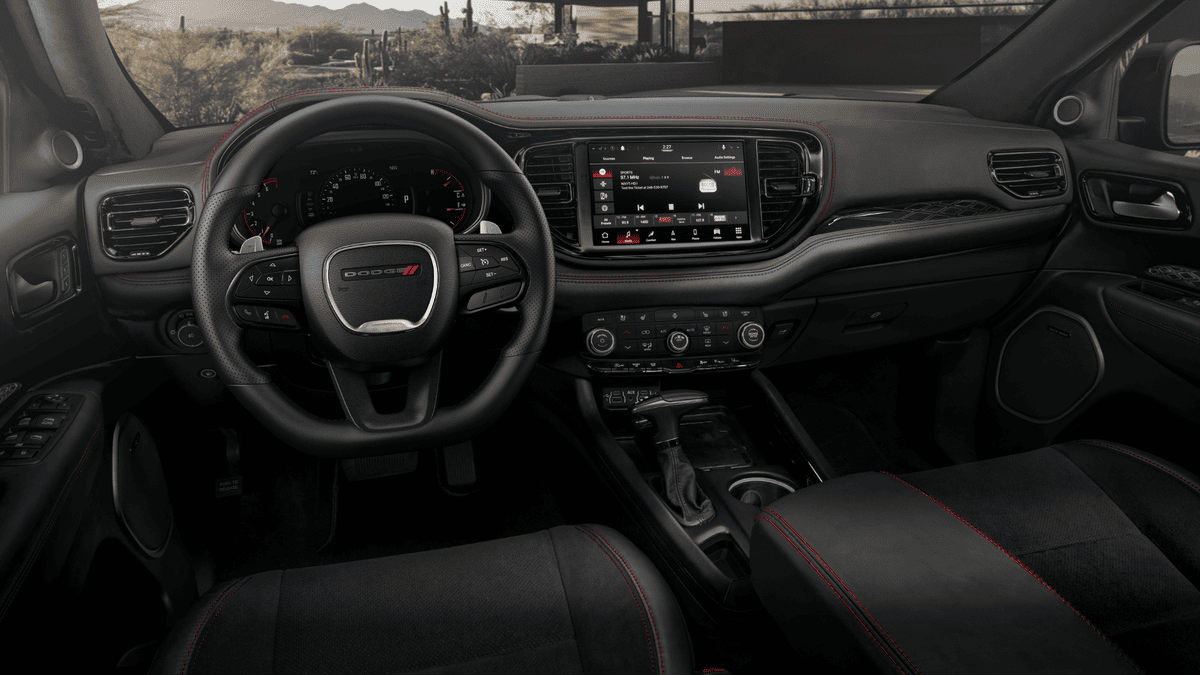 2026 Dodge Durango interior in Margate FL featuring Dodge-branded steering wheel, touchscreen infotainment display, black dashboard with red accent stitching, and center shifter