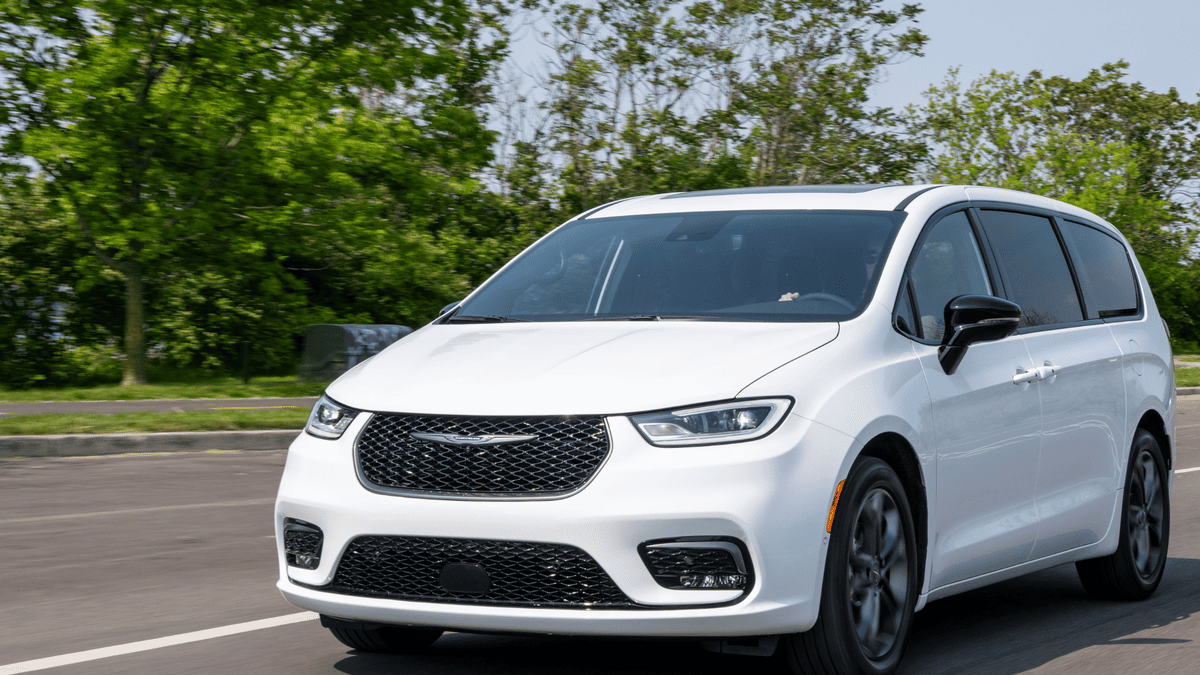 2026 Chrysler Pacifica in Margate FL in white driving on a road with black mesh grille, LED headlights, sliding rear doors, and blacked-out alloy wheels