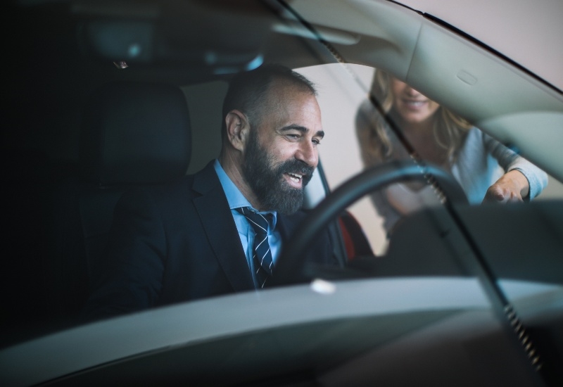 Two people are having a conversation inside a parked car on a roadside in Akron, OH.